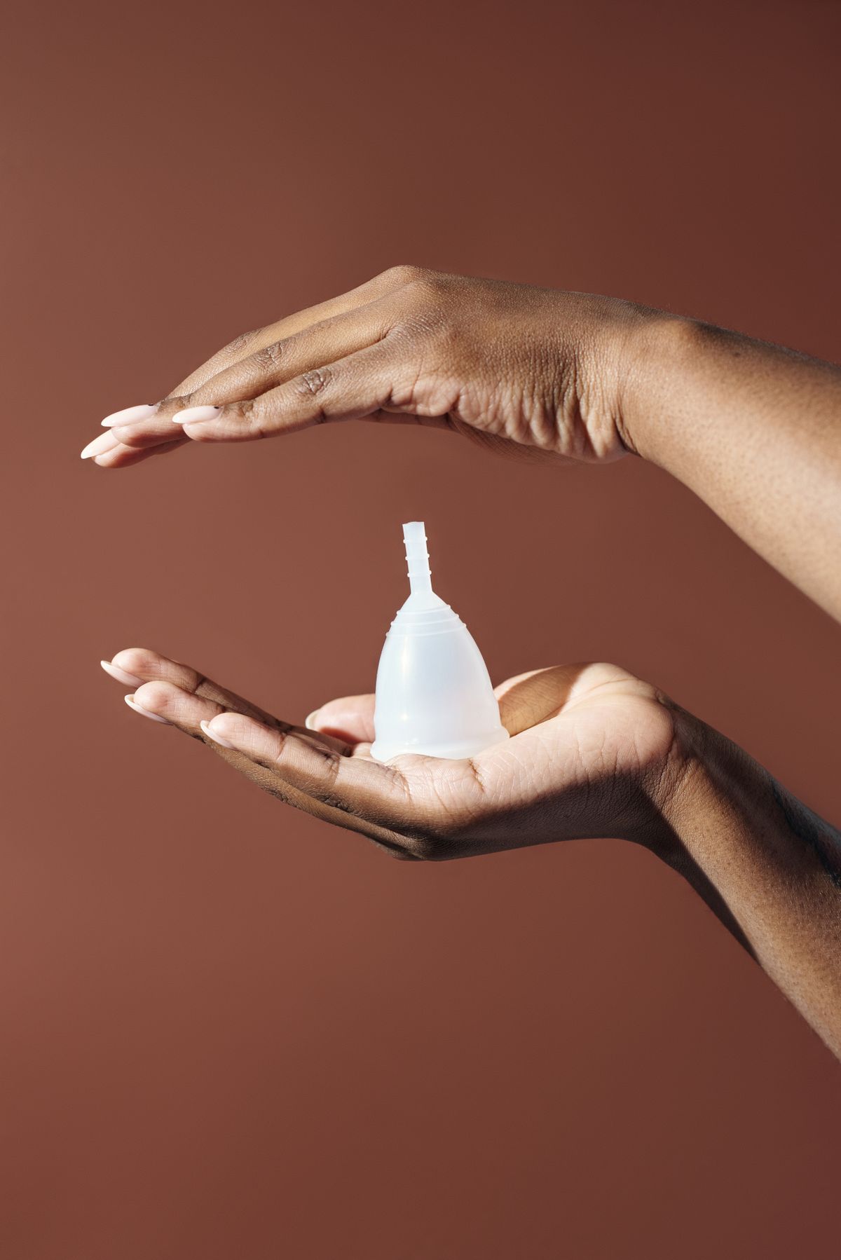 Hands holding silicone menstrual cup