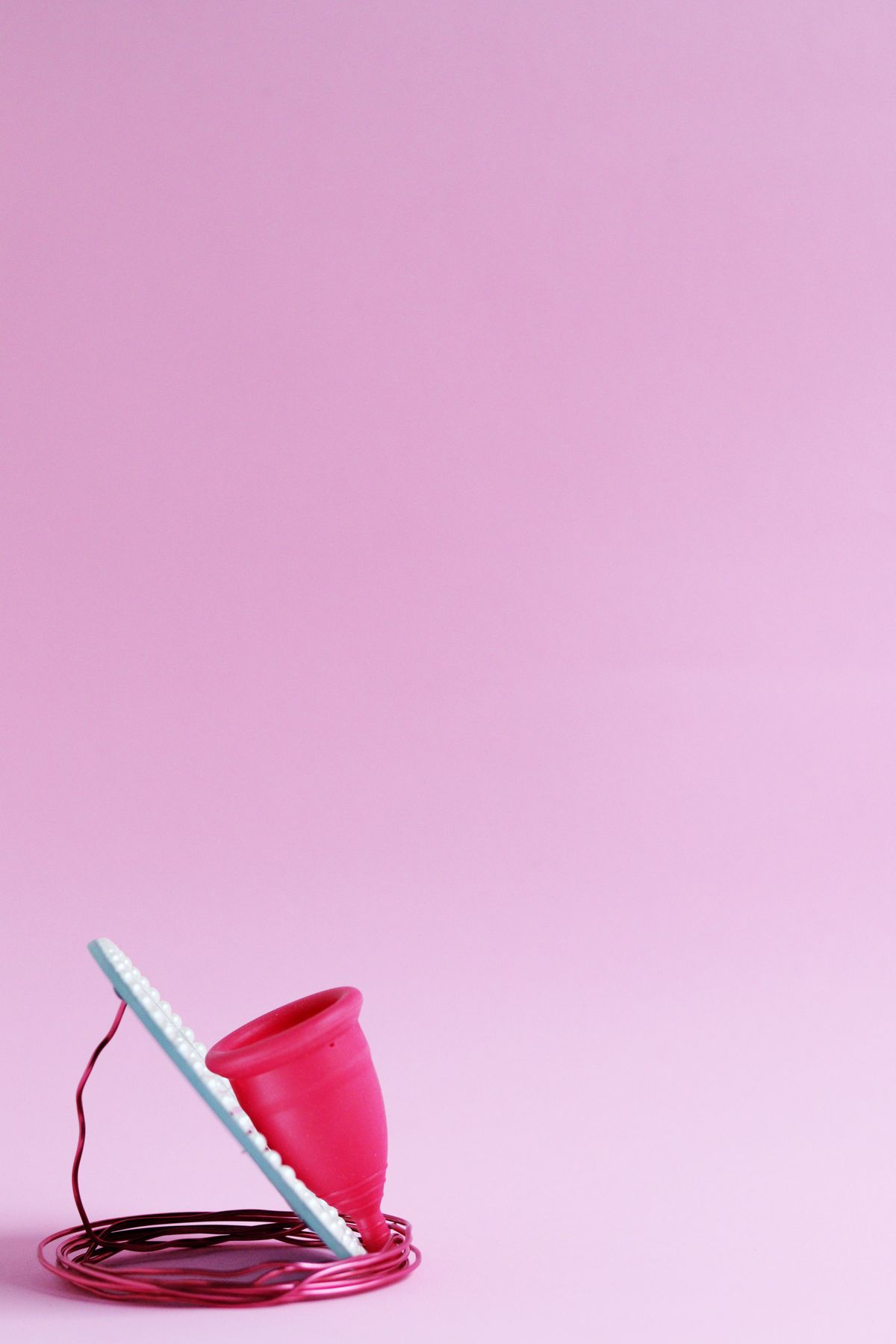 Menstrual cup on pink background